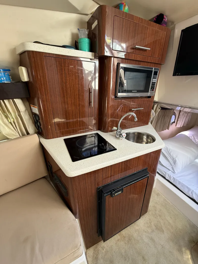 Slide: The Image of Interior of 2015 Regal 28 Express with kitchenette and sleeping area. - 12