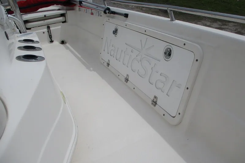 Slide: The Image of 2005 NauticStar 2200 NauticBay boat interior with storage compartment and rod holders. - 13
