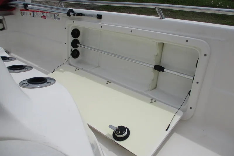 Slide: The Image of 2005 NauticStar 2200 NauticBay boat interior storage compartment with rod holders. - 14