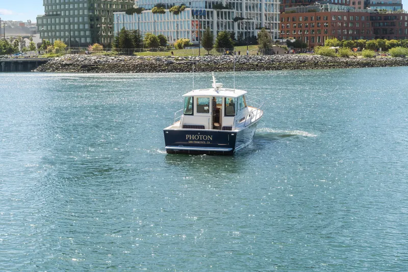 Slide: The Image of 2007 Sabre 42 Hard Top Express boat cruising near urban waterfront buildings. - 14
