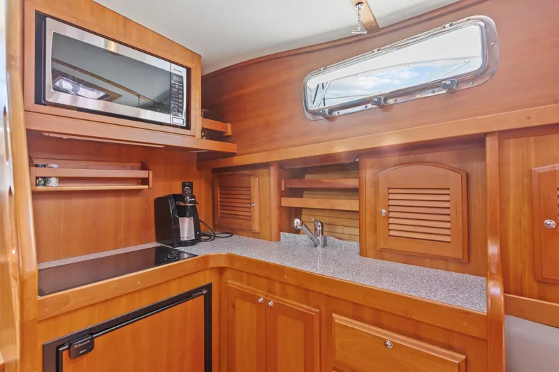 Slide: The Image of Luxurious 2007 Sabre 42 Hard Top Express yacht kitchen with wood cabinetry and modern appliances. - 24