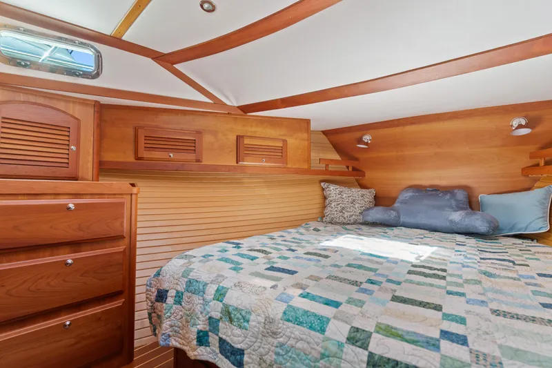 Slide: The Image of Cozy cabin interior of 2007 Sabre 42 Hard Top Express with quilted bedding and wooden cabinetry. - 30