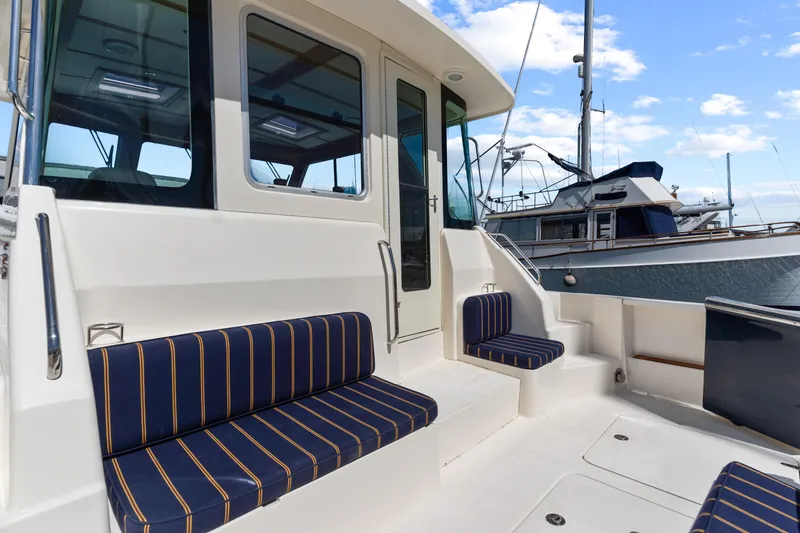 Slide: The Image of 2007 Sabre 42 Hard Top Express yacht with striped seating, docked at marina. - 5