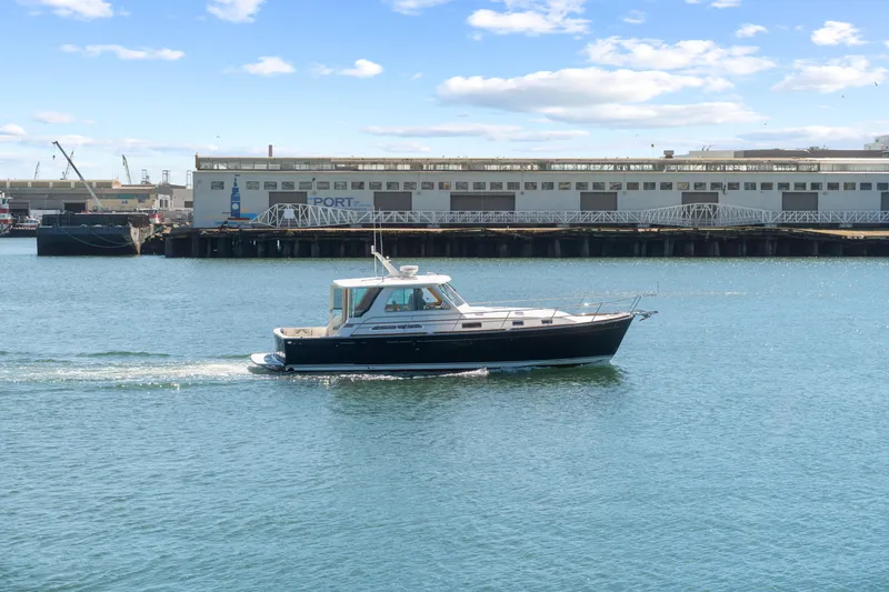 Slide: The Image of 2007 Sabre 42 Hard Top Express cruising near a port under a clear blue sky. - 9