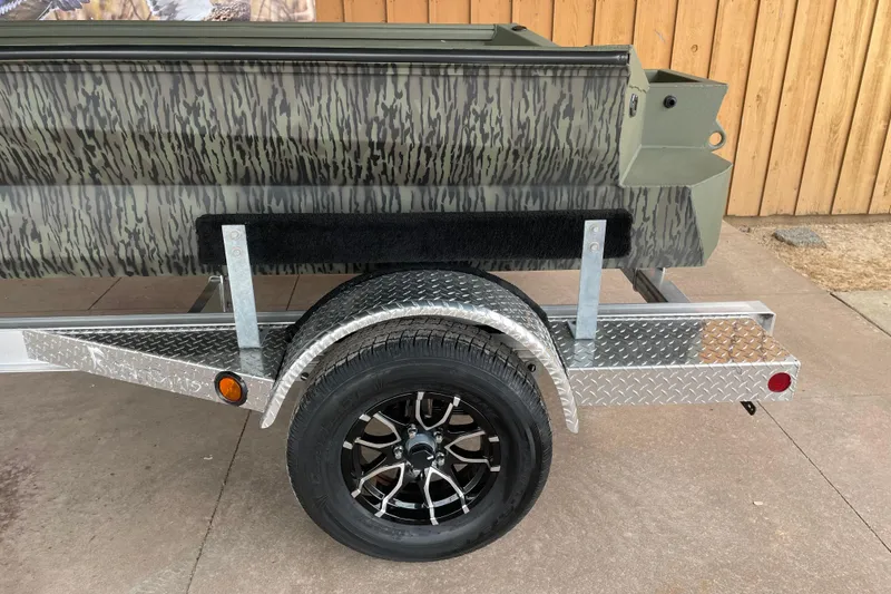 Slide: The Image of 2026 Reaper Boats 753 Timber Reaper on a diamond plate trailer with camouflage design. - 12