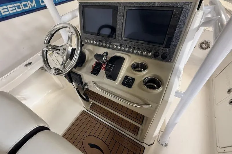 Slide: The Image of 2017 Crevalle 26 HCO boat console with dual screens and steering wheel. - 11