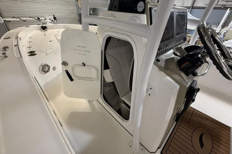 Slide: The Image of 2017 Crevalle 26 HCO boat interior with open storage compartment and steering console. - 13
