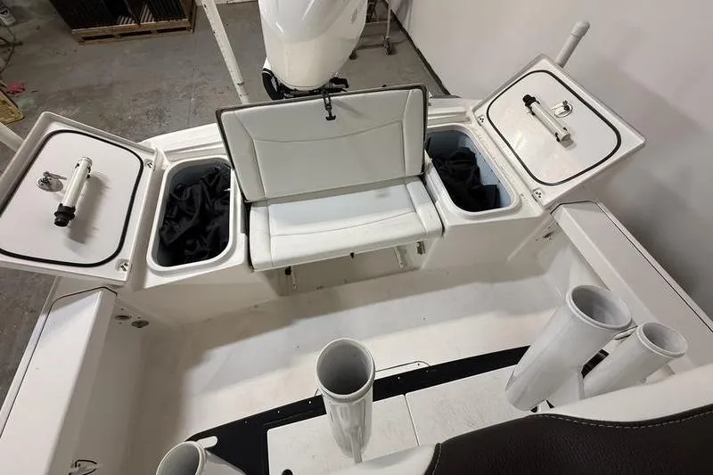 Slide: The Image of 2017 Crevalle 26 HCO boat interior with open storage compartments and rod holders. - 7