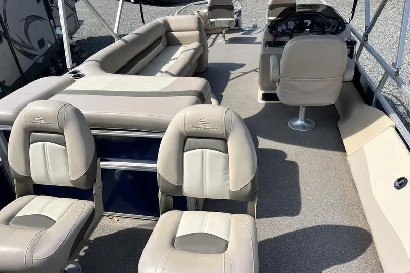 Slide: The Image of 2015 Sun Tracker Fishin' Barge 24 DLX interior with beige seating and steering console. - 12