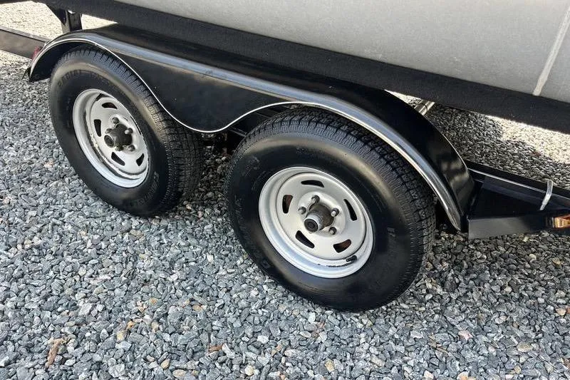 Slide: The Image of Trailer wheels of a 2015 Sun Tracker Fishin' Barge 24 DLX on gravel. - 8