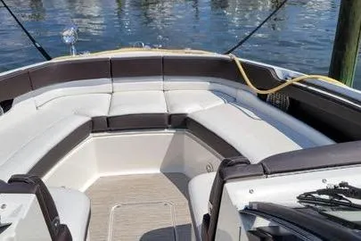 Slide: The Image of 2017 Sea Ray SLX 310 boat interior with cushioned seating, docked by the water. - 10