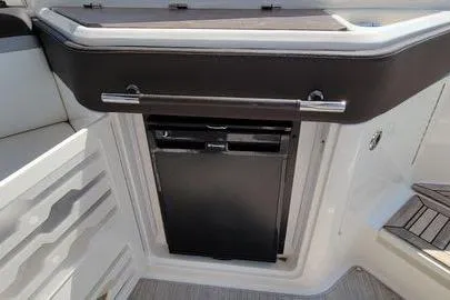 Slide: The Image of 2017 Sea Ray SLX 310 boat interior with built-in mini fridge. - 13