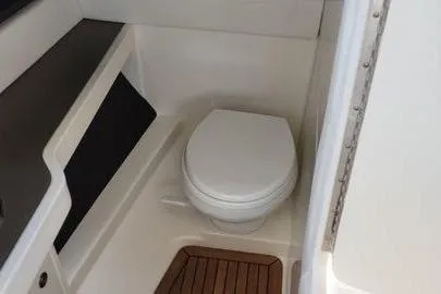 Slide: The Image of 2017 Sea Ray SLX 310 boat bathroom with toilet and wooden floor. - 14
