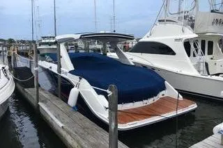 Slide: The Image of 2017 Sea Ray SLX 310 boat docked at marina with blue cover. - 2