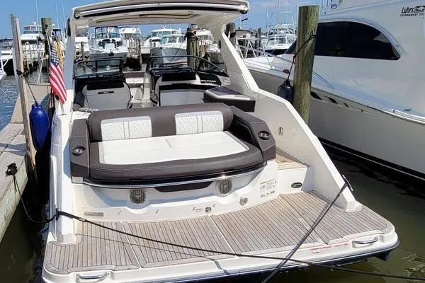 Slide: The Image of 2017 Sea Ray SLX 310 boat docked at marina with spacious seating area. - 6