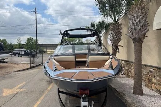 Slide: The Image of 2024 Supreme S220 boat parked outdoors near palm trees. - 1