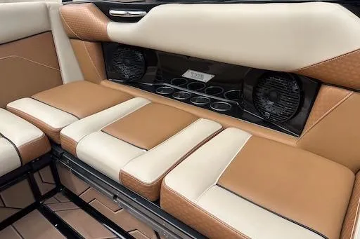 Slide: The Image of 2024 Supreme S220 boat interior with tan and cream seating, cup holders, and speakers. - 15