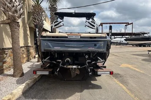 Slide: The Image of 2024 Supreme S220 boat rear view in a marina setting with palm trees. - 4