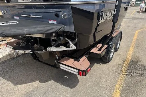 Slide: The Image of 2024 Supreme S220 boat on trailer, rear view showing propeller and dual axles. - 5