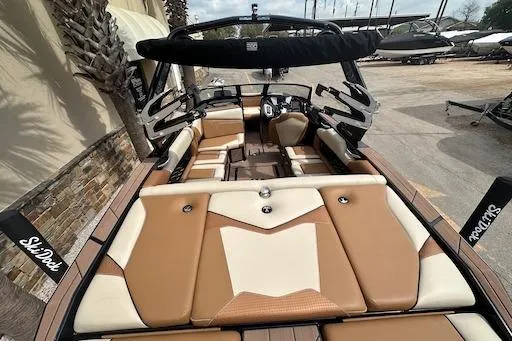 Slide: The Image of 2024 Supreme S220 boat with tan and white interior, docked outdoors. - 7