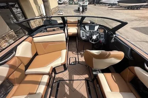 Slide: The Image of 2024 Supreme S220 boat interior with tan leather seating and modern dashboard. - 9
