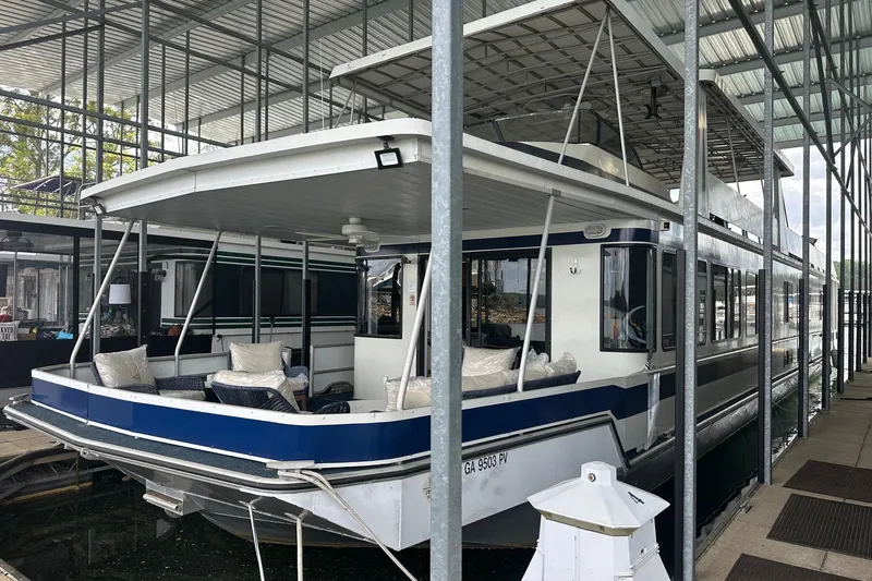 The Image of 1998 Stardust Cruisers 16x84 houseboat docked in a covered marina. - 0