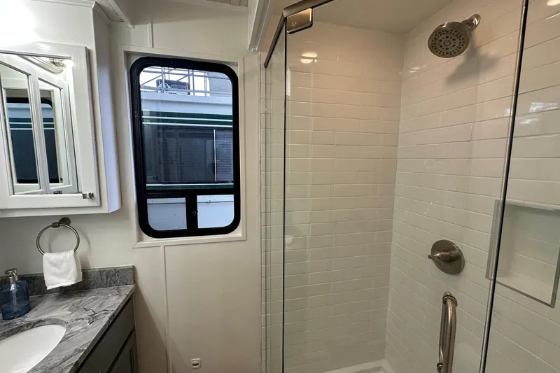 Slide: The Image of Modern bathroom with glass shower, marble countertop, and window in 1998 Stardust Cruisers 16x84. - 10