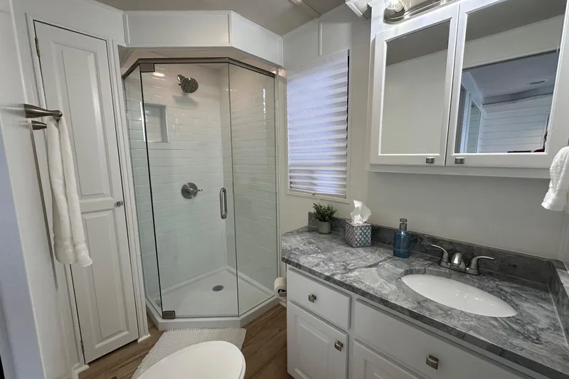 Slide: The Image of Modern bathroom in 1998 Stardust Cruisers 16x84, featuring glass shower and marble countertop. - 12