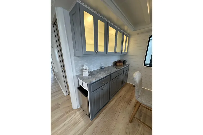 Slide: The Image of Modern kitchen interior in a 1998 Stardust Cruisers 16x84 houseboat, featuring sleek cabinetry. - 5