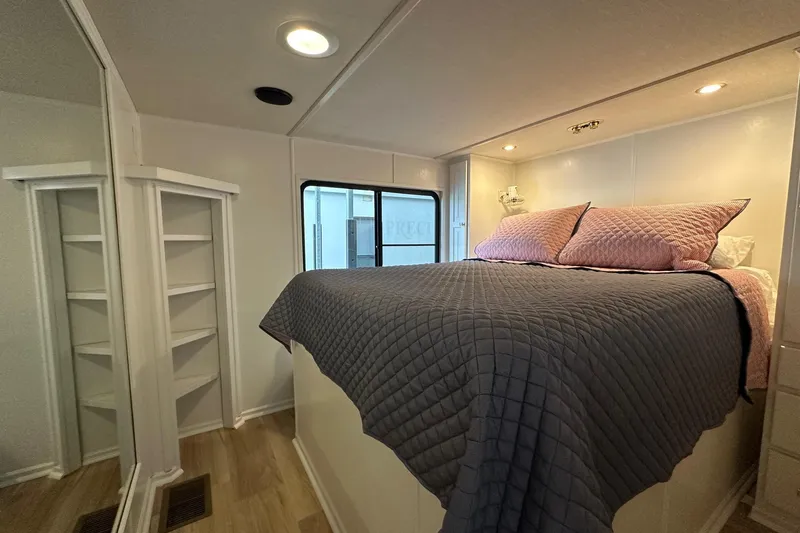 Slide: The Image of Cozy bedroom in 1998 Stardust Cruisers 16x84 houseboat with quilted bedding and built-in shelves. - 9