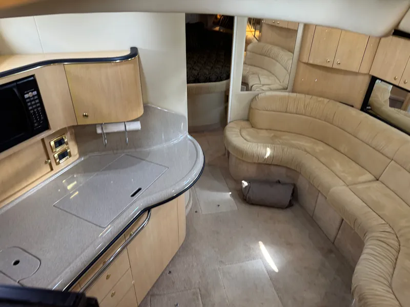 Slide: The Image of Interior of 1999 Sea Ray 380 Sundancer with kitchen and seating area. - 17