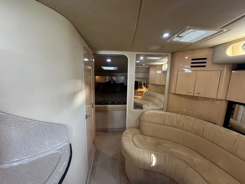 Slide: The Image of 1999 Sea Ray 380 Sundancer interior with beige sofa and cabinets. - 20