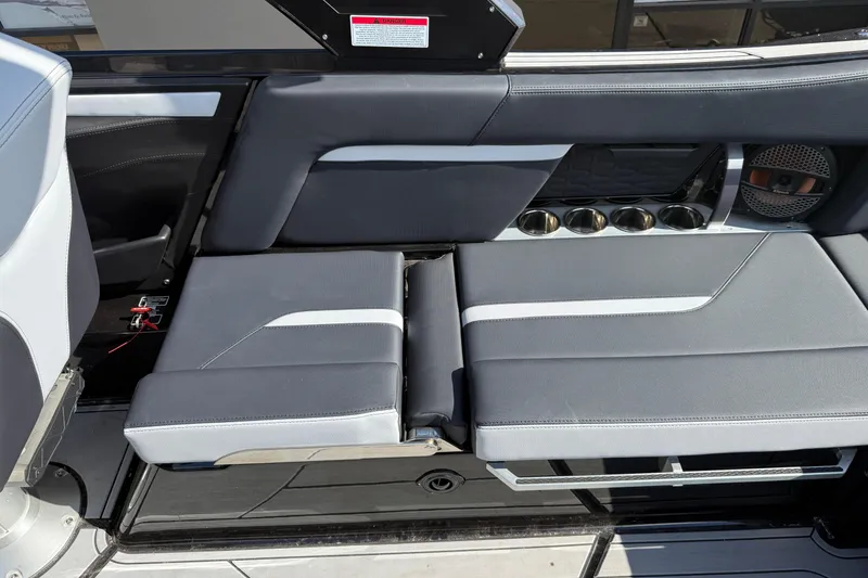 Slide: The Image of 2024 MasterCraft X24 boat interior with gray seating and cup holders. - 14