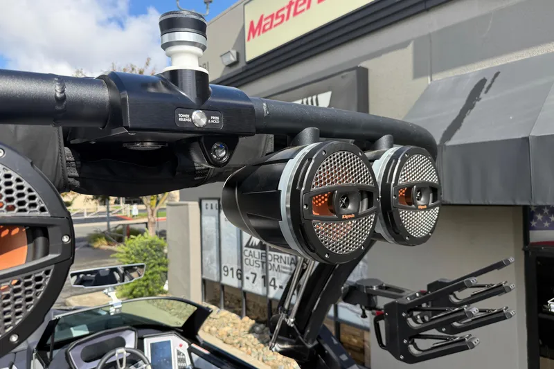 Slide: The Image of 2024 MasterCraft X24 boat with mounted speakers and tower release mechanism. - 28