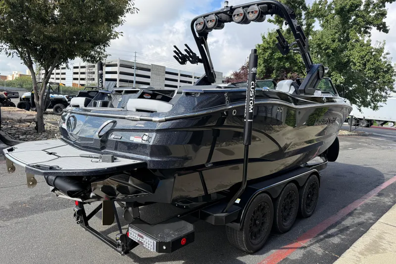 Slide: The Image of 2024 MasterCraft X24 boat on trailer, parked outdoors, showcasing sleek design and modern features. - 5