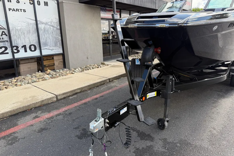 Slide: The Image of 2024 MasterCraft X24 boat on trailer, parked outside a building. - 9