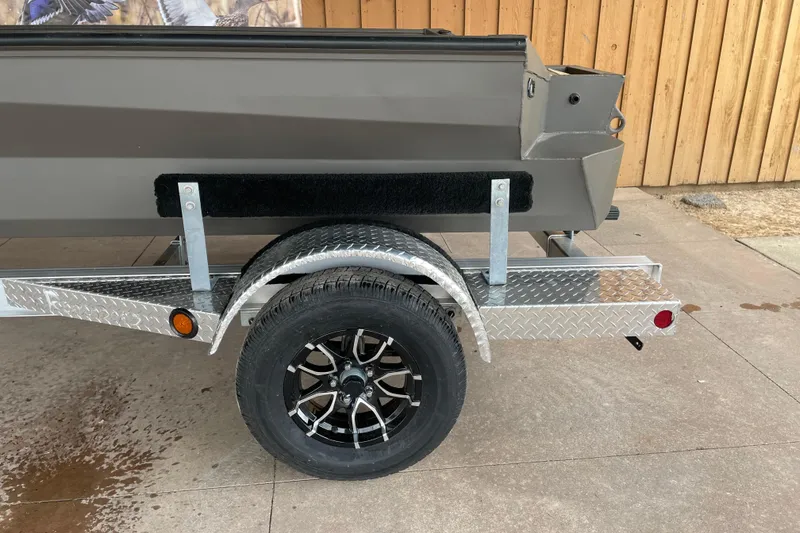 Slide: The Image of 2026 Reaper Boats 550 Timber Reaper trailer with black wheel and diamond plate fender. - 13