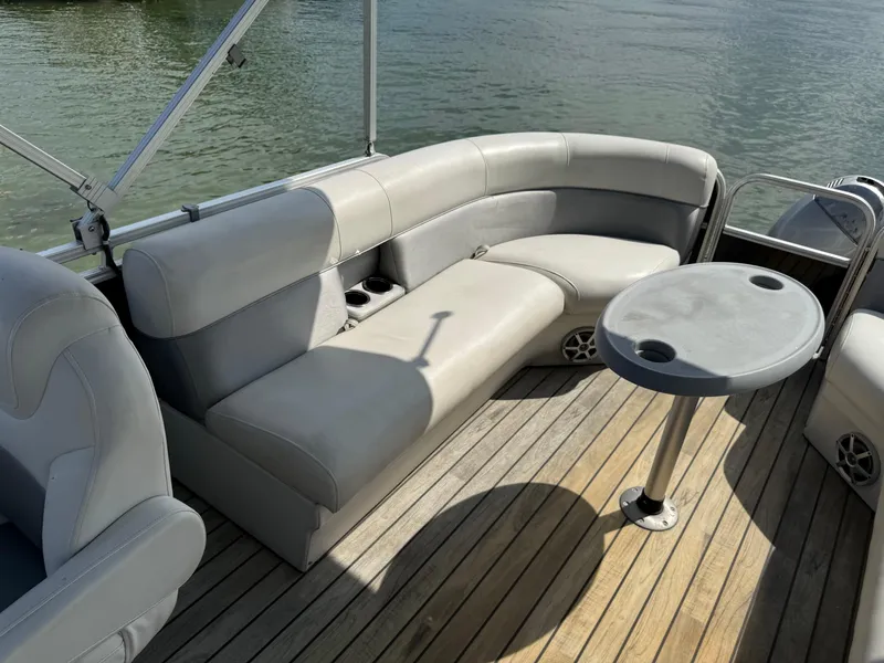 Slide: The Image of Sanpan 25 pontoon boat 2000 with gray seating and table on wooden deck. - 13