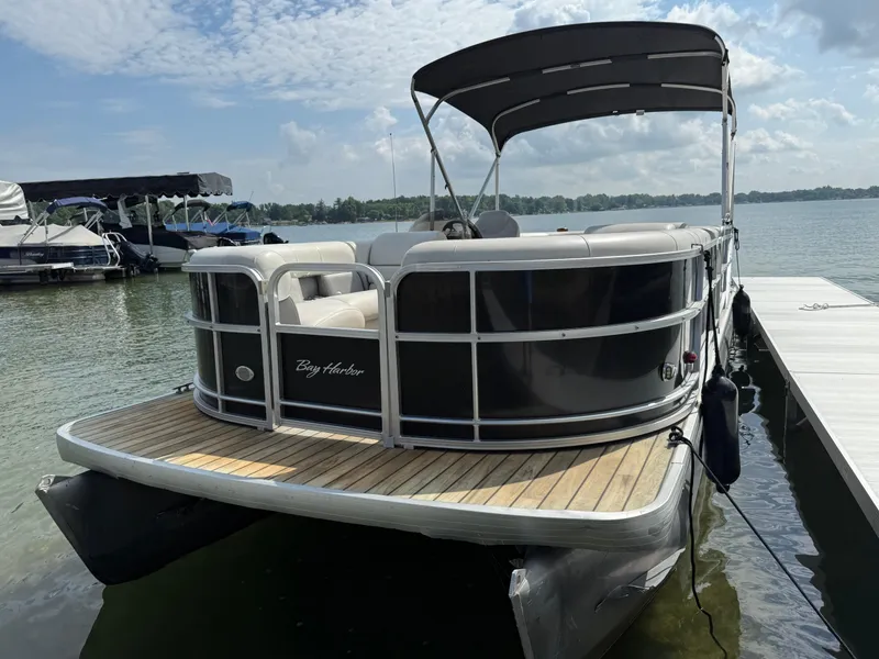 Slide: The Image of Sanpan 25 pontoon boat from 2000 docked on a sunny day. - 17