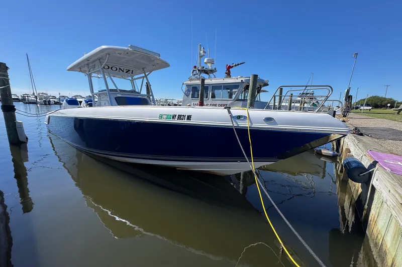 Slide: The Image of 2008 Donzi 32 ZF Open boat docked at marina under clear blue sky. - 2