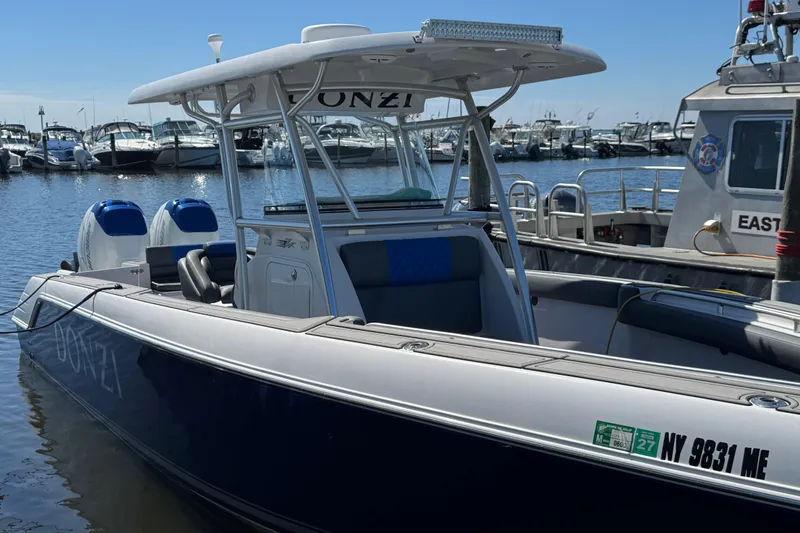 Slide: The Image of 2008 Donzi 32 ZF Open boat docked in marina, featuring sleek design and twin engines. - 3