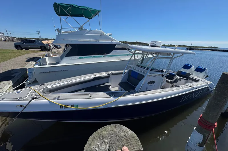 Slide: The Image of 2008 Donzi 32 ZF Open boat docked beside another vessel on a sunny day. - 4
