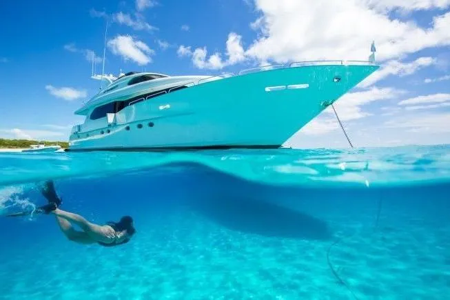 The Image of 2001 Lazzara Motoryacht anchored in clear blue water with a snorkeler swimming nearby. - 0