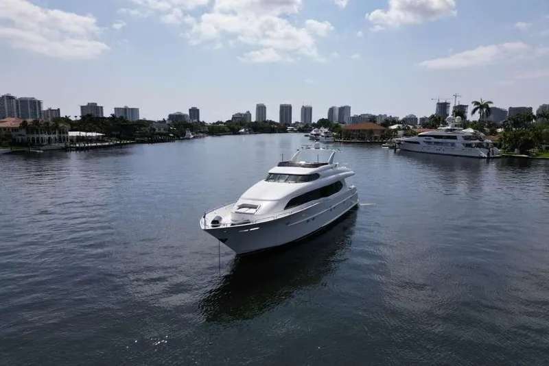 Slide: The Image of 2001 Lazzara Motoryacht cruising on a calm waterway with city skyline backdrop. - 11