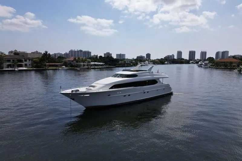 Slide: The Image of 2001 Lazzara Motoryacht cruising on a calm waterway with city skyline backdrop. - 12