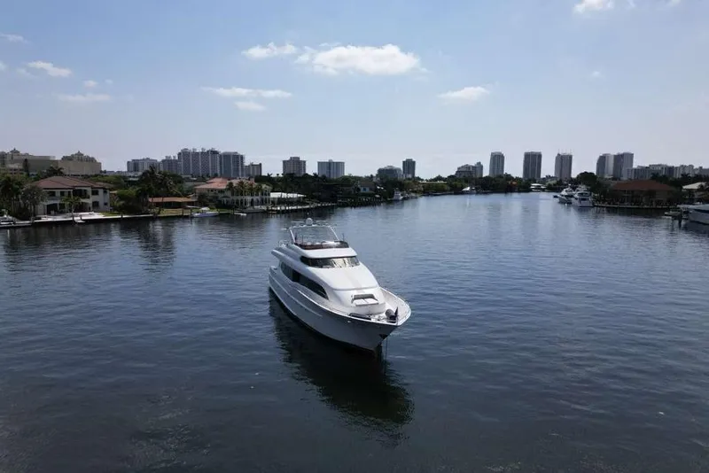 Slide: The Image of 2001 Lazzara Motoryacht cruising in a serene urban waterway with city skyline backdrop. - 22