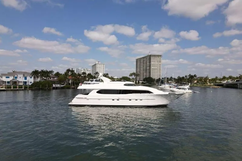 Slide: The Image of 2001 Lazzara Motoryacht cruising in a scenic marina with buildings and palm trees. - 3