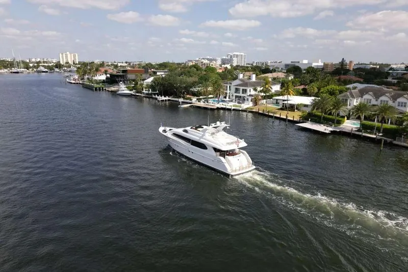 Slide: The Image of A 2001 Lazzara Motoryacht cruising along a scenic waterfront with luxury homes. - 5