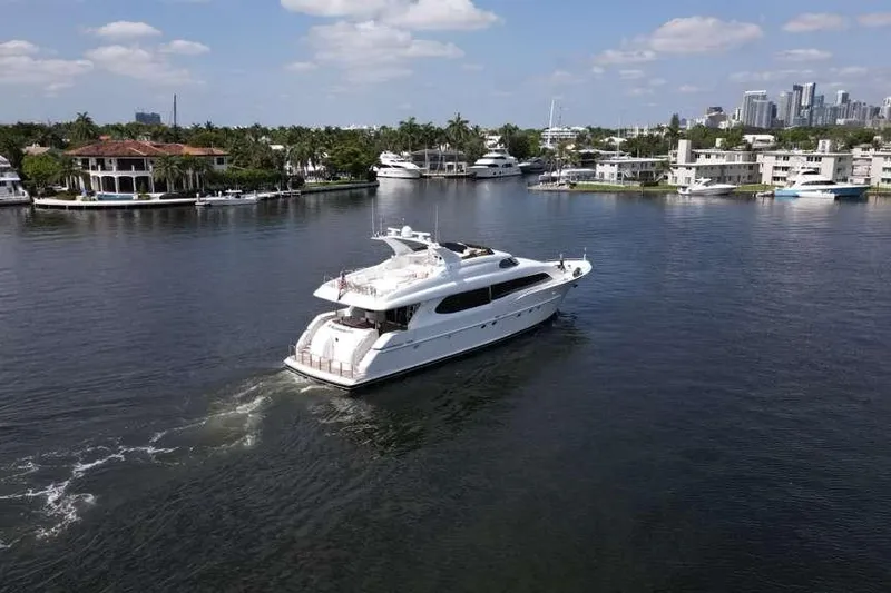 Slide: The Image of 2001 Lazzara Motoryacht cruising in a scenic waterfront area with luxury homes and yachts. - 6