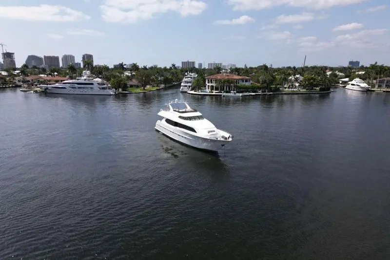 Slide: The Image of 2001 Lazzara Motoryacht cruising in a scenic waterfront area with luxury homes and yachts. - 8
